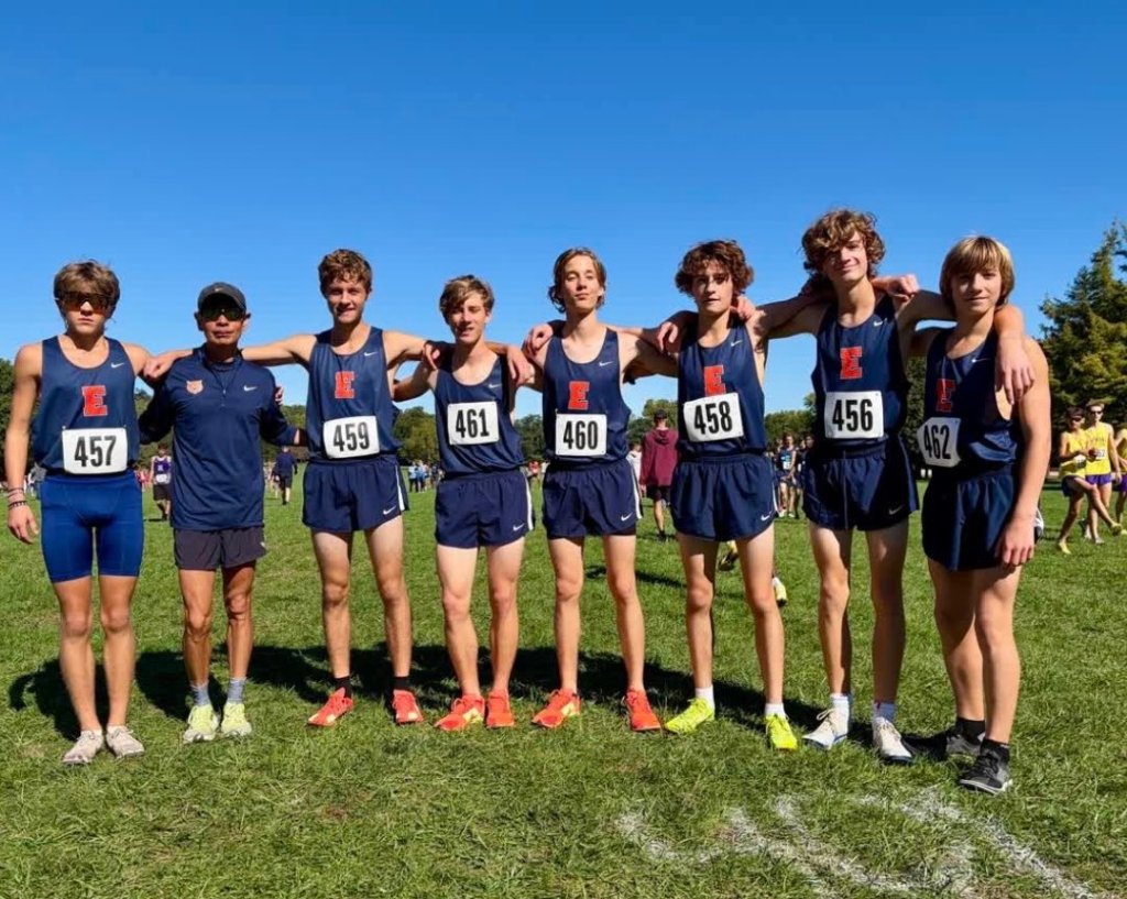 Evanston Wildkits cross country team running together on a scenic course, showcasing teamwork and determination.